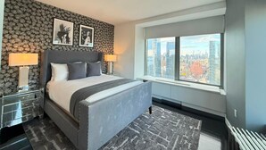 Et moderne hotelværelse med en stor seng, udsigt over byen og tapet med et mønster.
