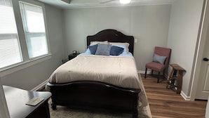 A bedroom with a bed, a chair, a nightstand, a ceiling fan, and a window with blinds. - Welcome to “The Hideaway”..a cozy chalet in the heart of the Bourbon Capital (Bardstown)