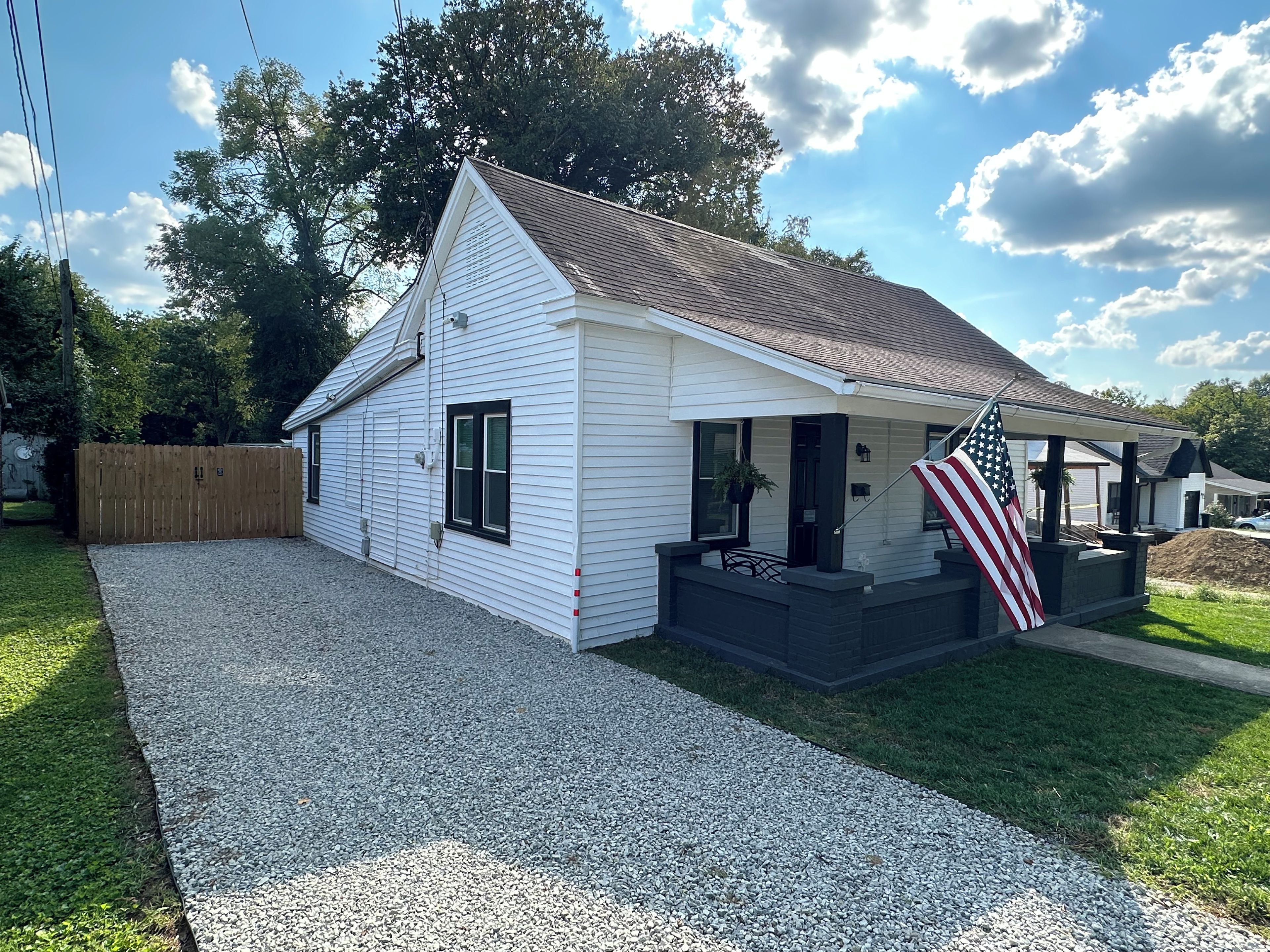 A single-story house with a gravel driveway and a wooden fence.