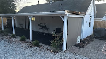 Un espace extérieur abrité comprenant une terrasse, un barbecue et un coin salon.