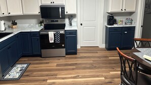 A kitchen with white cabinets, a microwave, a stove, and a coffee maker. - Welcome to “The Hideaway”..a cozy chalet in the heart of the Bourbon Capital (Bardstown)