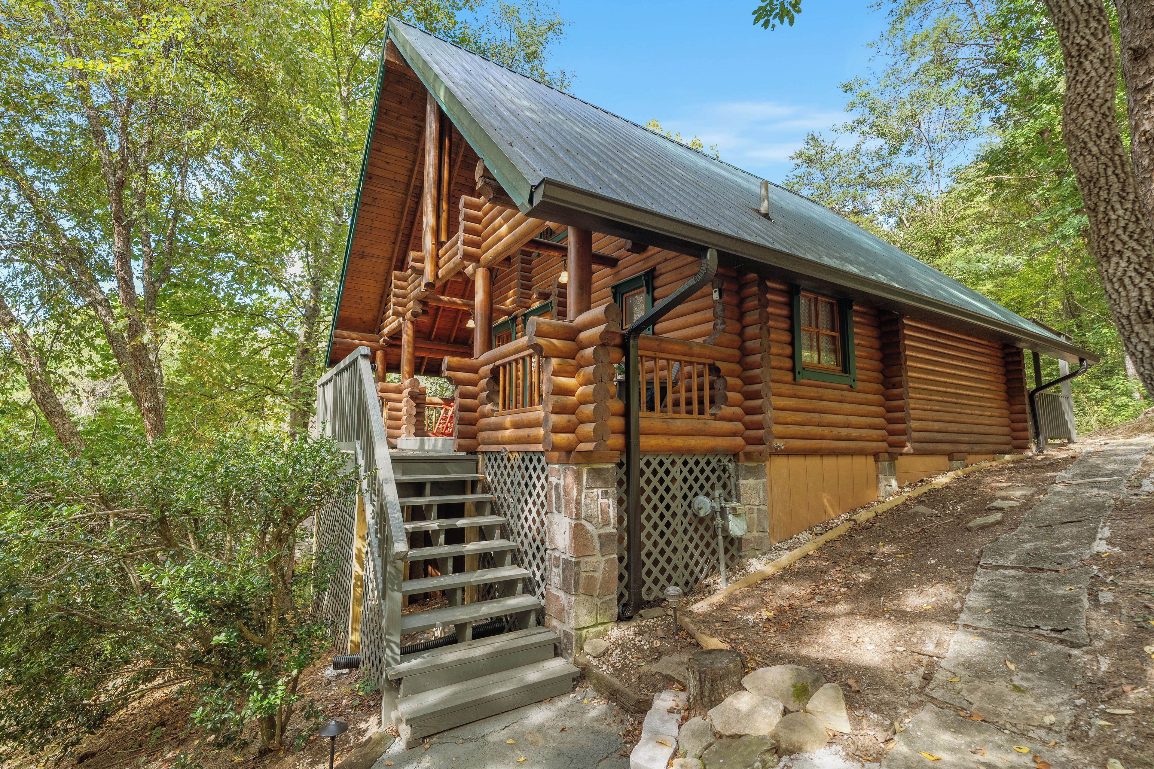 Eine Blockhütte mit Veranda, Holzstufen und einer Steinmauer.