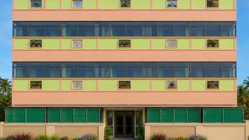A multi-story building with a flat roof, large windows, and a central entrance.