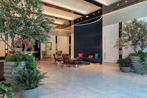 A spacious lobby with a seating area, large potted plants, and a modern design. - Deluxe E11EVEN Studio Suite with Elite Amenities (Miami)
