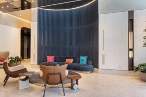 A modern lounge area with a sofa, chairs, and a small table. - Deluxe E11EVEN Studio Suite with Elite Amenities (Miami)