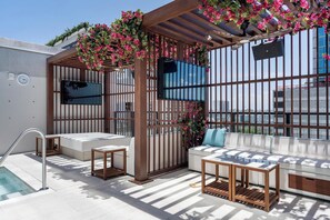 A rooftop terrace with a pool, seating area, and a pergola with flowers. - Deluxe E11EVEN Studio Suite with Elite Amenities (Miami)