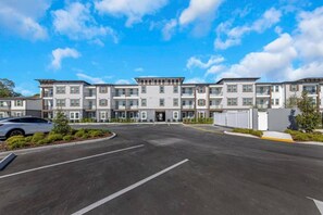 A multi-story residential building with a parking lot in front. - Spacious Largo Escape | Poolside 2BR Stay (Largo)