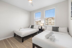 A hotel room with two beds, a ceiling fan, and a window with blinds. - Spacious Largo Escape | Poolside 2BR Stay (Largo)