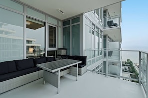 Ein Balkon mit einer Couch, einem Tisch und Stühlen mit Blick auf die Stadt.
