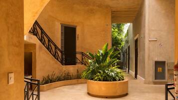 Un patio circular con un macetero central, una escalera y una puerta marcada con el número 201.