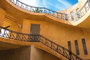 A multi-level building with a curved staircase and balconies. - Hotel Casa Nuuma (Merida)