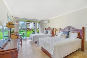 Une chambre d’hôtel avec deux lits, un bureau et une vue sur un jardin.