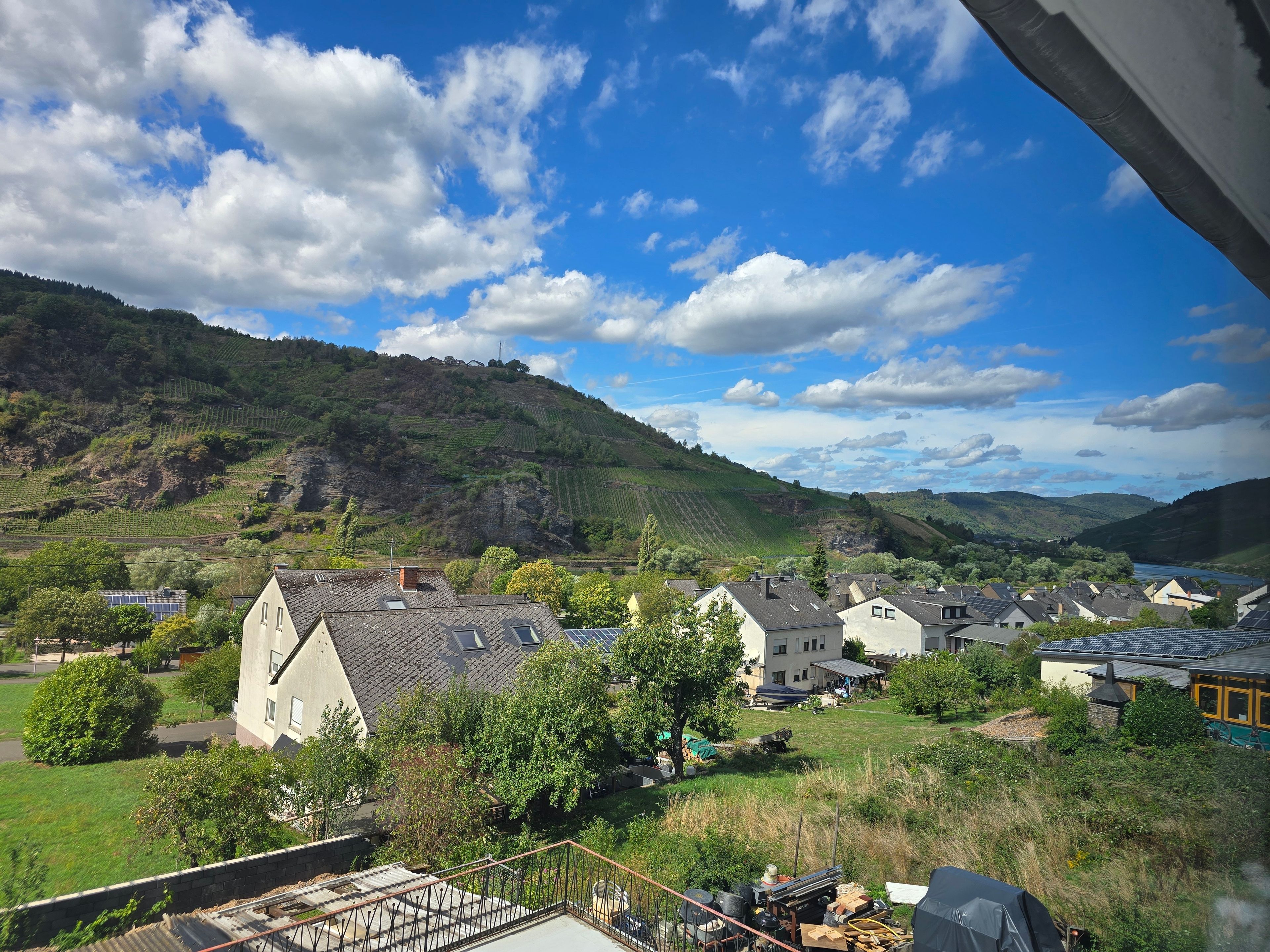 A residential area with houses, a hill, and a river.