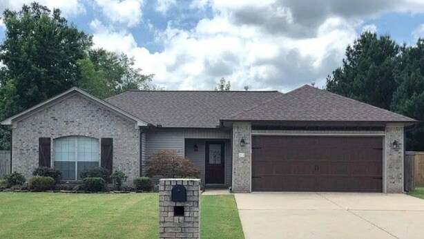 A two-story house with a garage, a front lawn, and a mailbox. - Cozy Cabot 3 bedroom (Cabot)