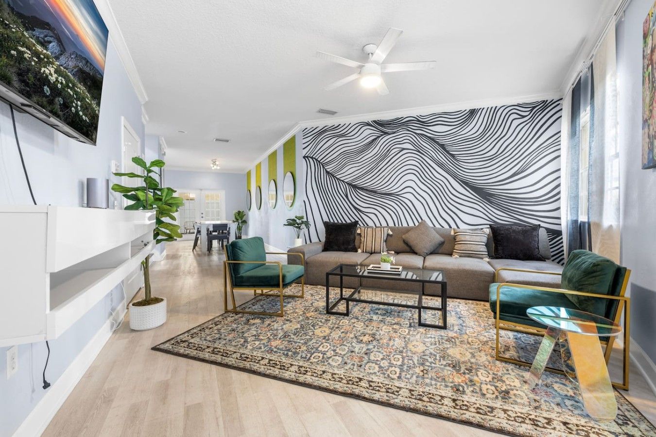 A modern living room with a sofa, two armchairs, a coffee table, and a patterned rug.