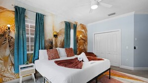 Quarto com cama, cortinas, painel na parede, ventilador de teto e porta.