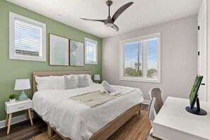 A bedroom with a bed, bedside tables, a desk, and a ceiling fan. - Downtown Tampa Retreat | Dining & Riverwalk (Tampa)