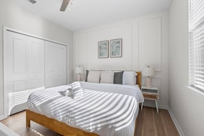 Una camera da letto con un letto, comodini, un armadio e due quadri appesi al muro.