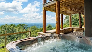Un jacuzzi con cubierta de madera y vistas a montañas.