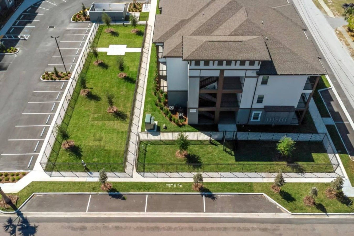 A multi-story building with a parking lot and landscaped areas.