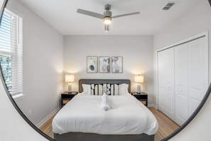 A bedroom with a bed, two bedside tables with lamps, a ceiling fan, and a wardrobe. - Cozy Largo Stay | Pool, Gym & Free Parking (Largo)