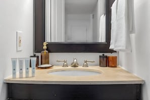 Een badkamer met een wastafel, spiegel en toiletartikelen.