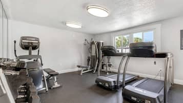 A home gym with treadmills, a stationary bike, and free weights.