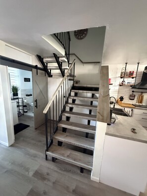 A modern kitchen with white cabinets, a wooden countertop, and a built-in stove. - 3-Bed. Modern loft with gated parking near SJU (San Juan)