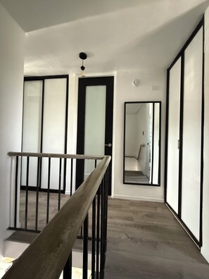 A staircase with a wooden handrail leading to a landing. - 3-Bed. Modern loft with gated parking near SJU (San Juan)