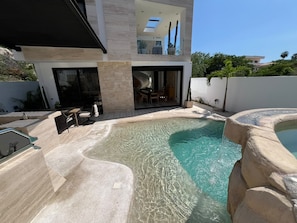 A modern house with a swimming pool, outdoor seating, and a patio area. - Villa Velas | Private Pool, Hot Tub & Rooftop | Gated Cabo Bello (Cabo San Lucas)