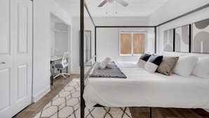 Un dormitorio con cama con dosel, un escritorio con silla, un armario y una ventana con persianas.