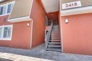 Ein Gebäude mit roter Außenfassade, einer Treppe, die zu einem Eingang führt, und einem Schild mit der Hausnummer 2418.
