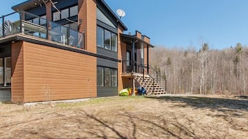 Un bâtiment moderne à deux étages, doté de grandes fenêtres, d’un balcon et d’une antenne parabolique.
