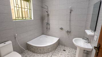 Un baño con bañera, lavamanos e inodoro.