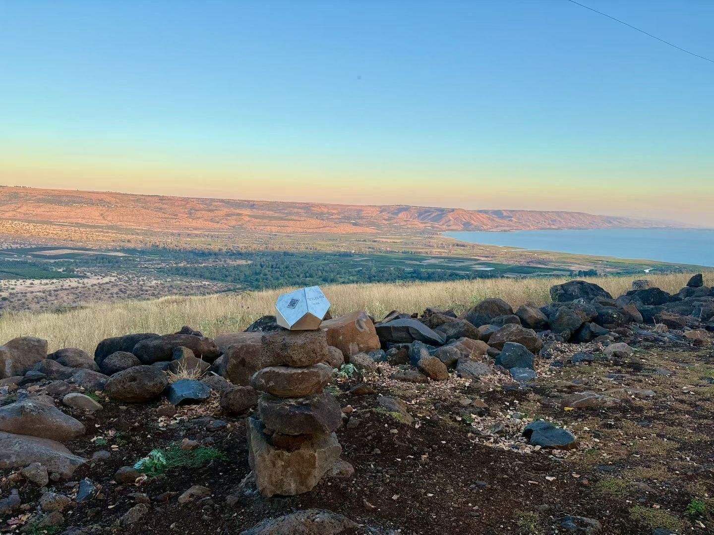 A rocky landscape with a clear view of distant hills and a body of water.