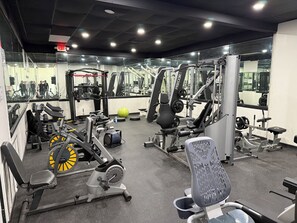 A gym with various exercise equipment, mirrors, and a yellow exercise ball. - Charming 2-bedroom townhome with pool and other HOA amenities (Pharr)