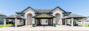 A large building with a central entrance, two side wings, and a covered parking area. - Charming 2-bedroom townhome with pool and other HOA amenities (Pharr)