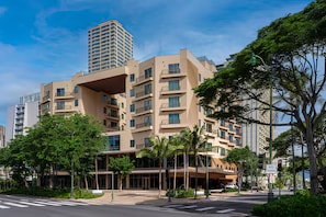 Een hotel met meerdere verdiepingen, met een modern architectonisch ontwerp, en voorzien van balkons en grote ramen.