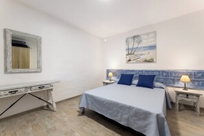 A bedroom with a bed, two bedside tables, a dresser, a painting, and a mirror. - Home2Book Casa Yoyo Lanzarote Coastal Home (El Golfo)