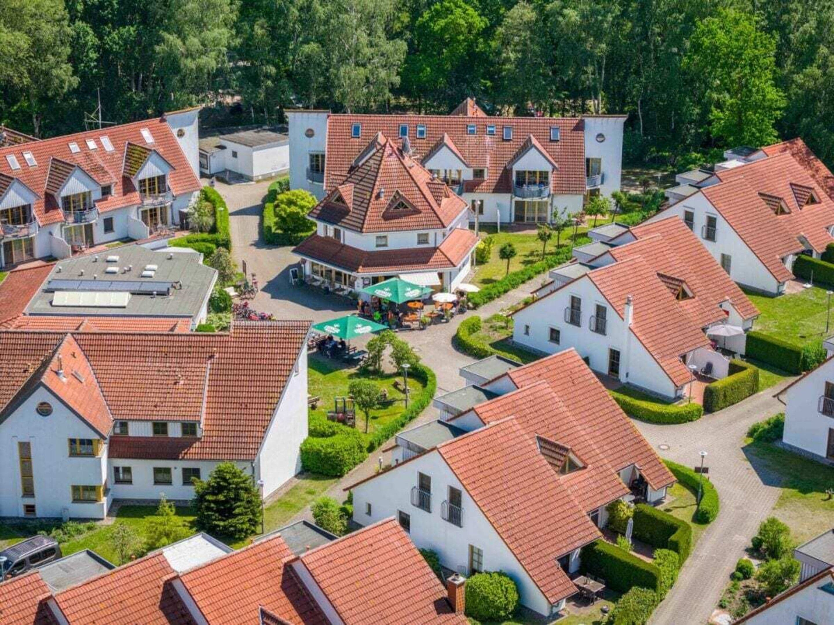 A residential area with multiple houses, each featuring a red-tiled roof and white walls.