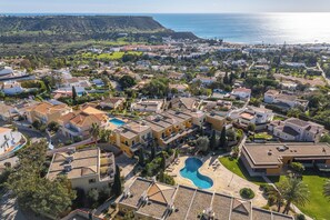 Ein Wohngebiet mit Häusern, einem Swimmingpool und Blick aufs Meer.