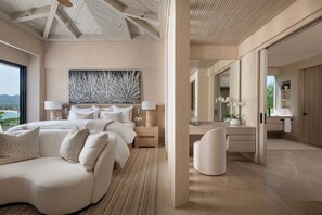 Une chambre moderne avec un grand lit, des tables de chevet, un bureau et une chaise. Une grande fenêtre offre une vue sur l’extérieur.