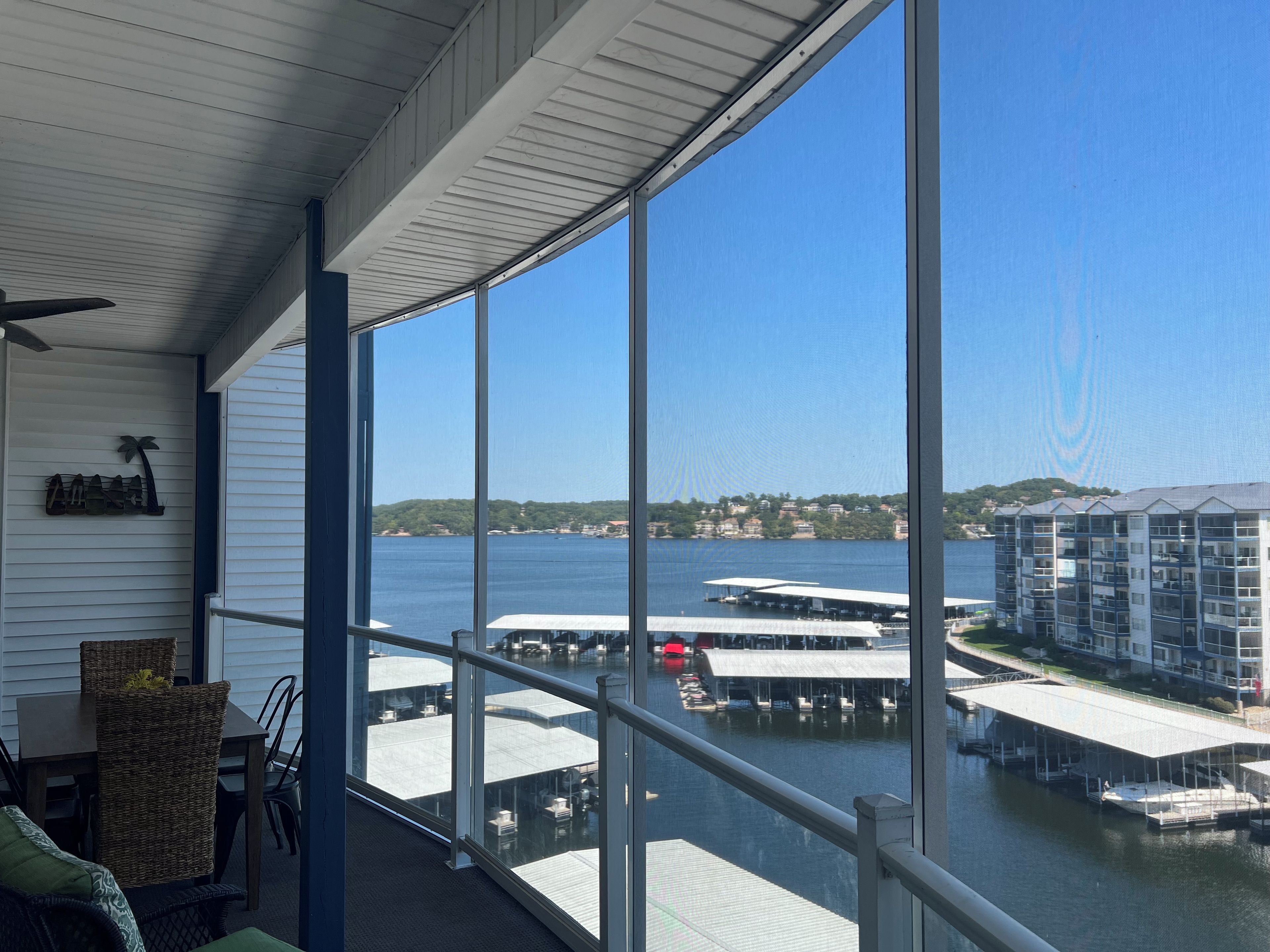 A balcony with a view of a marina and buildings across the water.