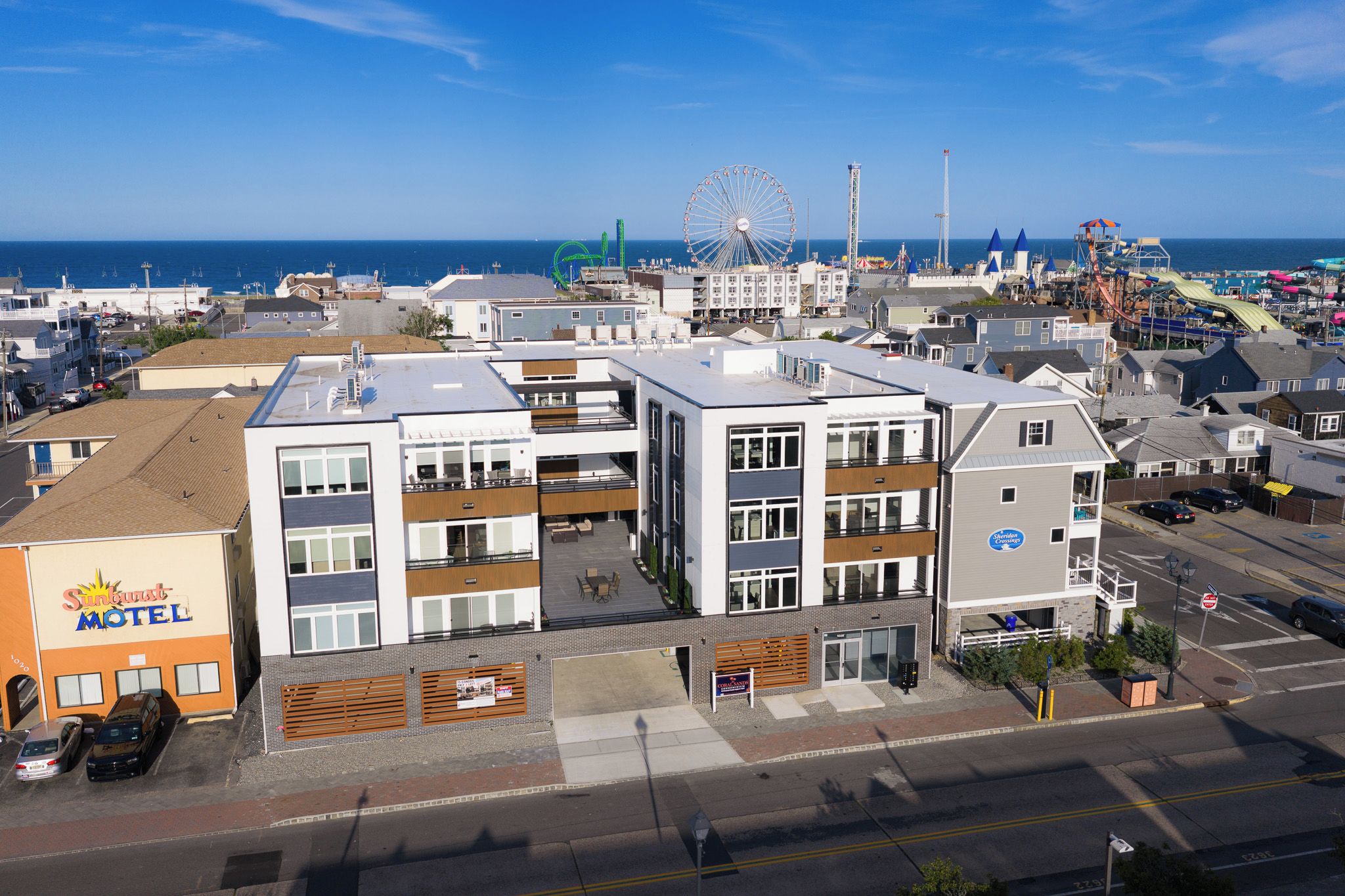 A multi-story motel with a visible outdoor seating area and a Ferris wheel in the background.