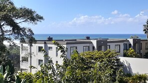 Zona residencial con edificios modernos, vistas al mar y abundante vegetación.