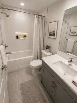 Ein modernes Badezimmer mit Badewanne, Toilette und Waschbecken.