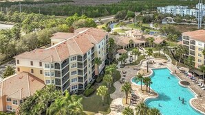 Et resort med flere etagers bygninger, en central pool og frodig beplantning omkring.