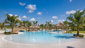 A large outdoor swimming pool with lounge chairs and palm trees. - Marvelous 2-bedroom condo with upgraded amenities in Margaritaville Hilton Head. (Hardeeville)