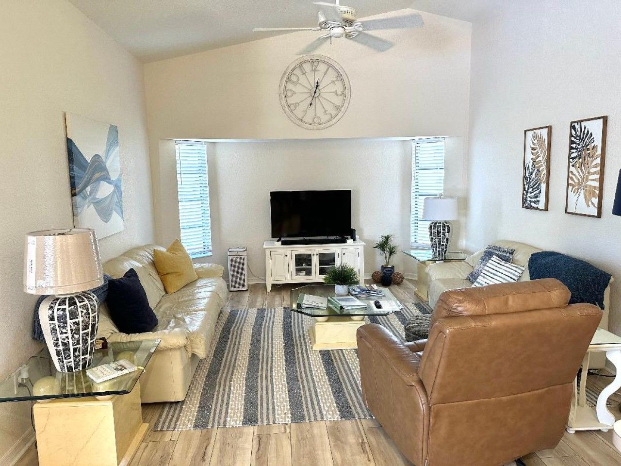 A living room with a television, sofa, coffee table, and decorative items.