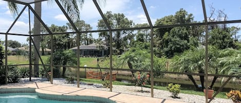 Une piscine offrant une vue dégagée sur le paysage environnant, avec notamment des arbres et un bâtiment situé au loin.